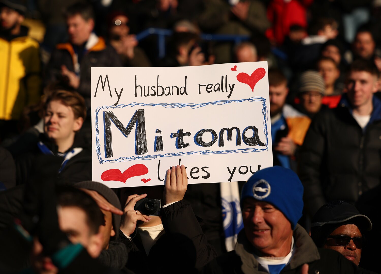 現地ファン、手書きの応援ボードも。「Mitoma, My husband really likes you（私の夫はミトマが大好きよ）」 ©AFLO