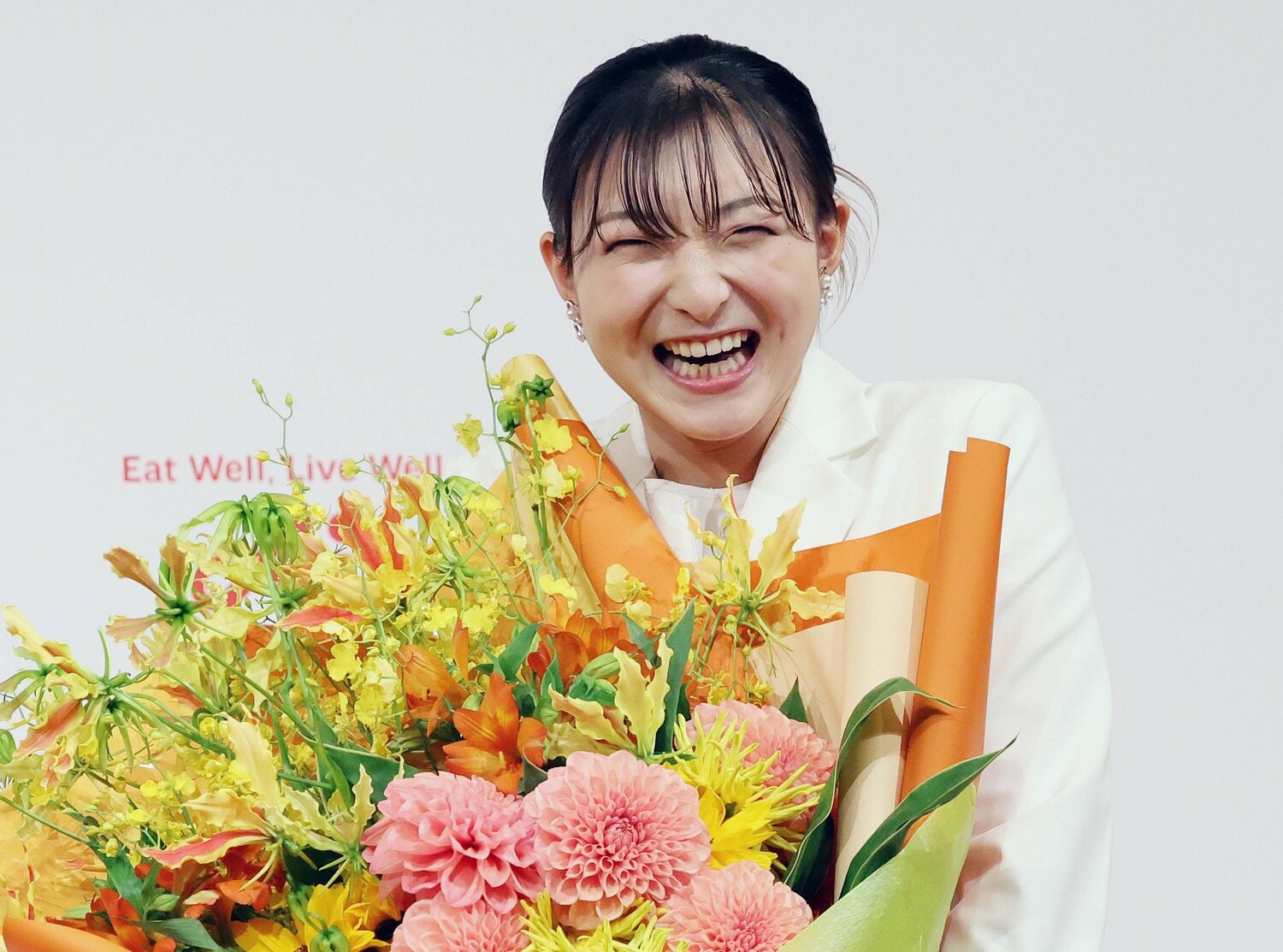 花束を受け取り笑顔の坂本　©JIJI PRESS