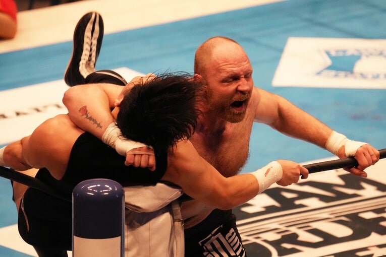 コーナーの成田蓮にラリアットを放つジョン・モクスリー　©Essei Hara