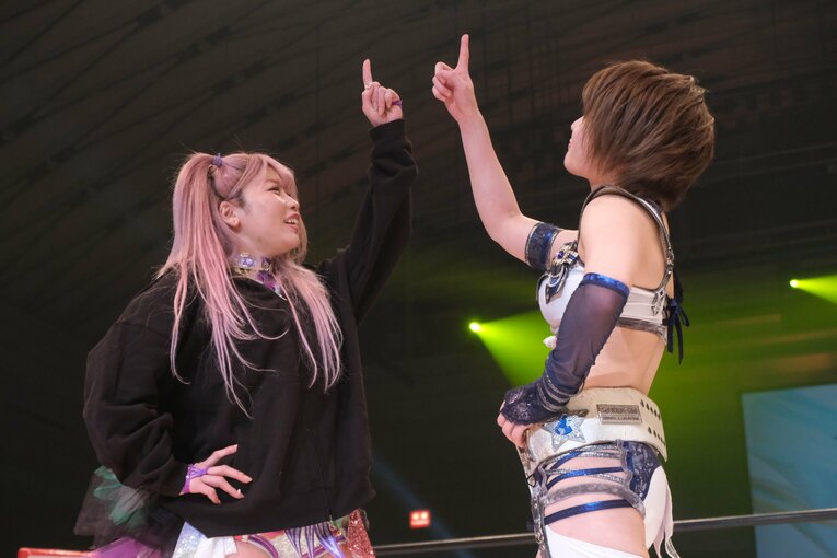 向かい合い、ともに上方を指さした安納とたむ