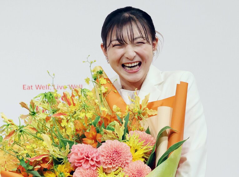 花束を受け取り笑顔の坂本　©JIJI PRESS