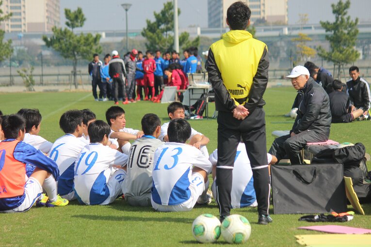 古沼氏（右）の話を真剣に聞く河田（奥）ら大津高校サッカー部　©︎Takahito Ando