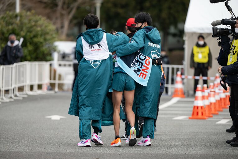 5区で首位・駒澤大と差を離された脇田はうずくまって、仲間に支えられる　©Nanae Suzuki