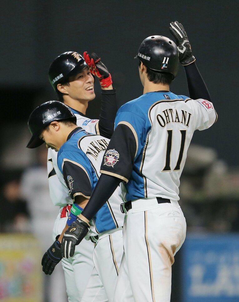大谷翔平とハイタッチする岡大海　©︎JIJI PRESS
