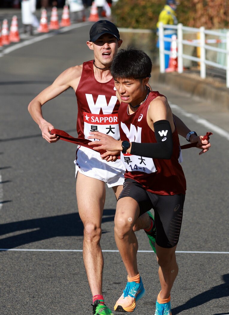 2023年1月の箱根駅伝。平塚中継所で、早大7区の鈴木創士（4年、左）からタスキを受ける8区の伊福（2年）　©JIJI PRESS　