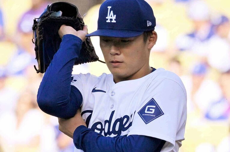 ロイヤルズ戦の1回、右腕をもむドジャース先発の山本由伸 ／ photograph by JIJI PRESS