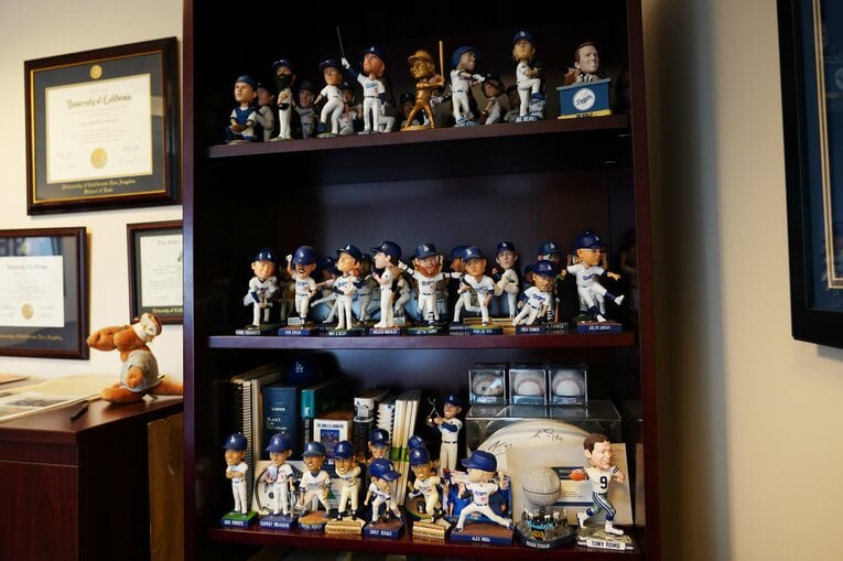ドジャースのボブルヘッドコレクターのジョン・シュア弁護士の職場。事務所の個室オフィスに棚を設置し、ボブルヘッドを陳列 ©︎Shizuka Minami