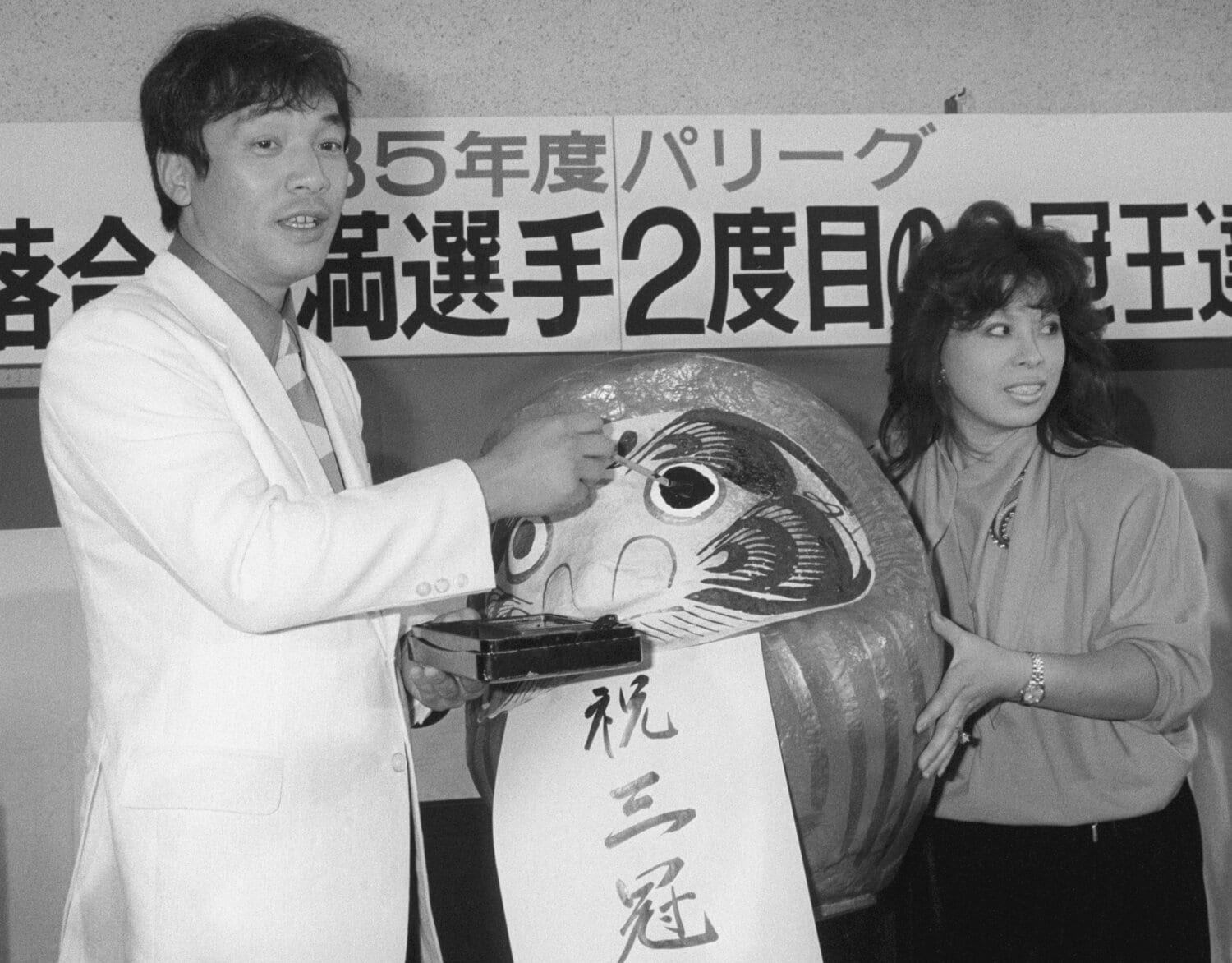 1985年、2度目の三冠王が決まり、ダルマに目を入れる落合と信子夫人。10月22日、新宿のロッテ球団事務所で　©KYODO