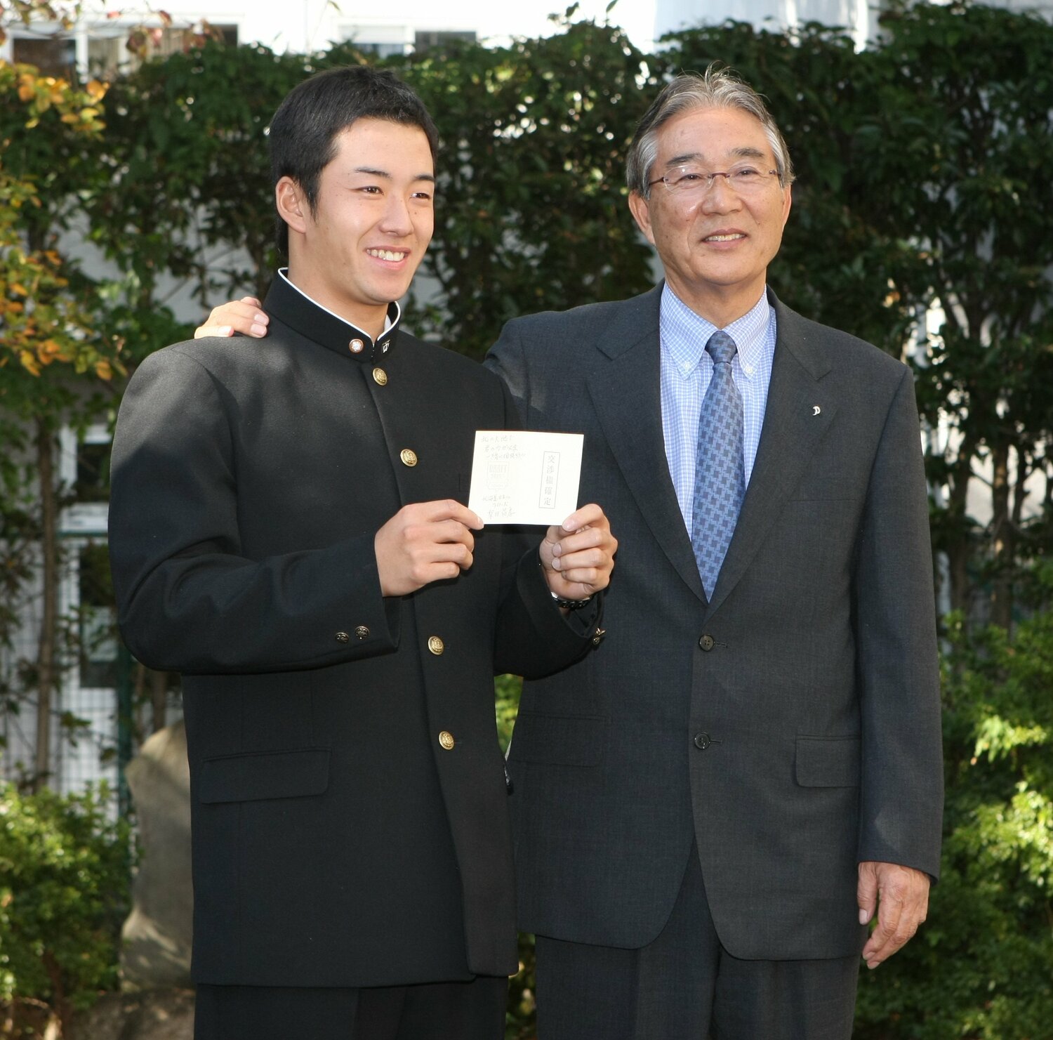 1位で引き当てた斎藤佑樹の指名挨拶に訪れた当時GMの山田正雄氏(左) ©︎JIJI PRESS