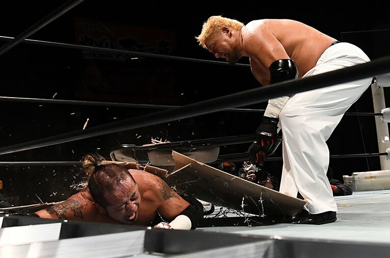 有刺鉄線ボードごとパイプ椅子で葛西純（左）を叩く石川修司。彼らが過激なデスマッチを闘う理由とは ／ photograph by Masashi Hara