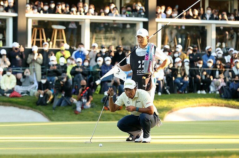 イーグルパットへ芝目を読む松山英樹。早藤キャディ（後方）も優勝を手繰り寄せるスーパーショットに驚きを隠せない様子だった ／ photograph by Getty Images