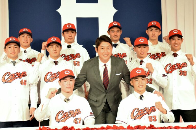 新入団選手記者会見で、新人に囲まれてポーズを取る新井監督。この中から世代交代を担う人材は現れるか？ ／ photograph by JIJI PRESS