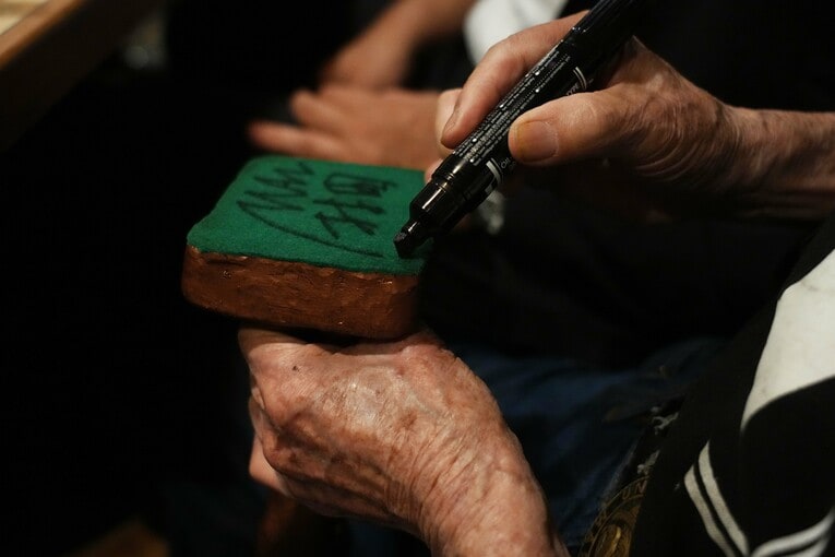 ブロンズ像の底にサインを入れる村田善則マスター　©Essei Hara