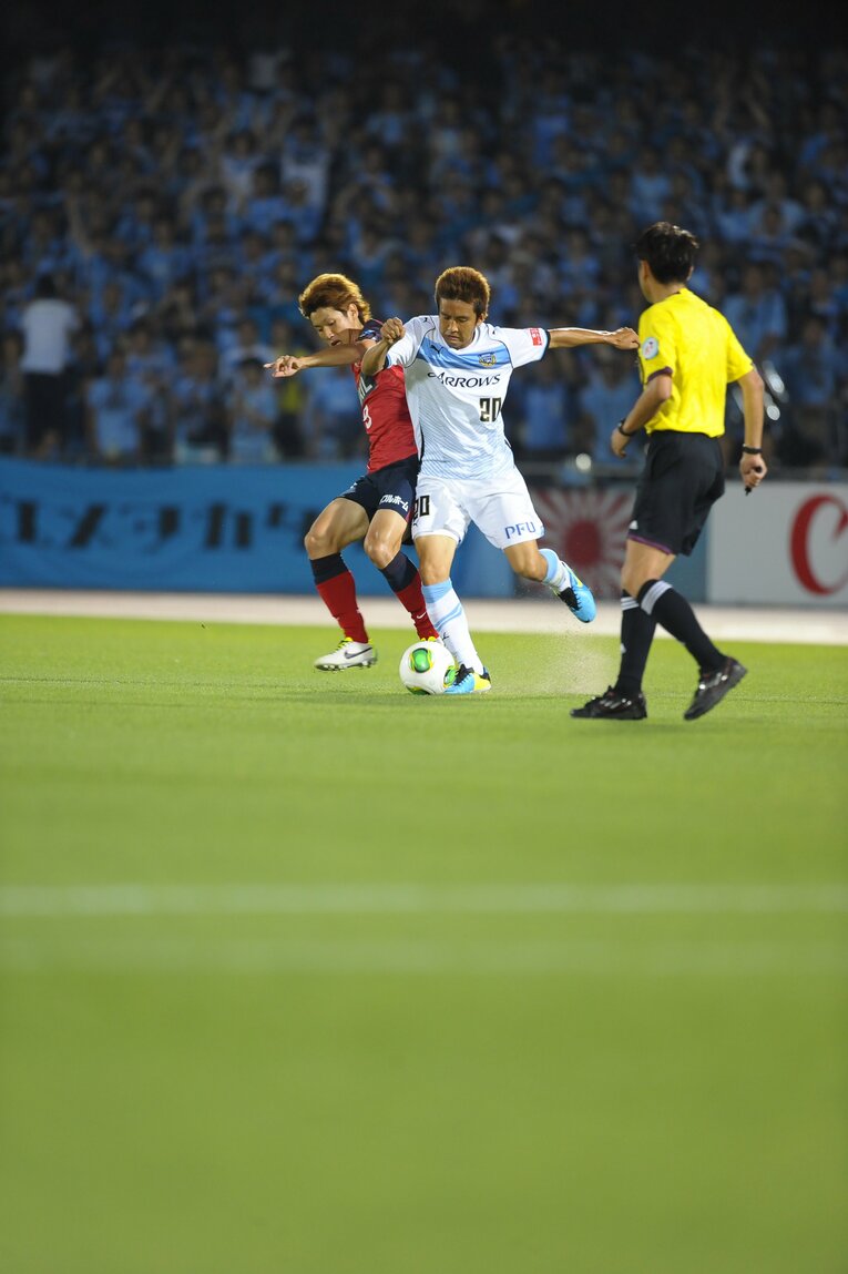 大迫勇也と激しくボールを奪い合う　©Toshiya Kondo