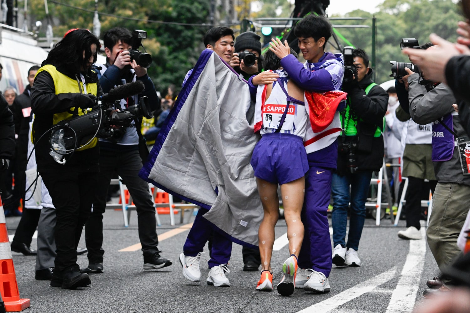 ゴールした10区の庭瀬俊輝（3年）を柔らかな表情で出迎えた鈴木と副将の金子（左）　©Nanae Suzuki