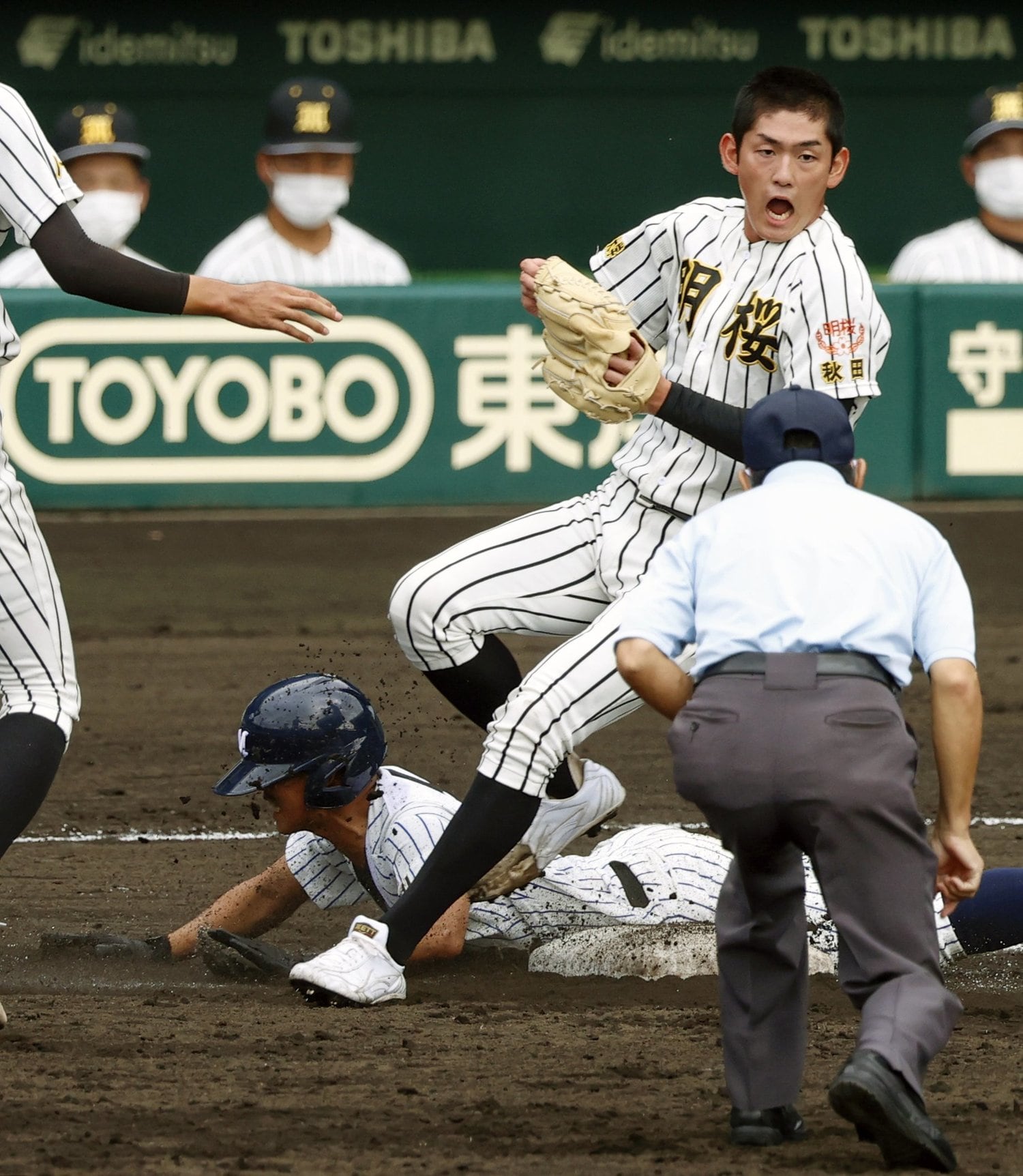3回表明徳義塾がタイムリー内野安打で1点目。一塁へ滑り込む森松（下）とベースカバーの風間球打。明徳義塾はプロ注目の風間に6回139球を投げさせ、2番手以降の投手を打ち崩した　©KYODO