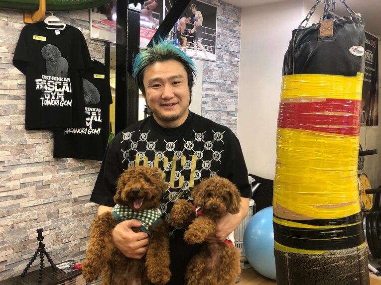 愛犬を抱えて笑顔を覗かせる五味　©︎Shimei Kurita