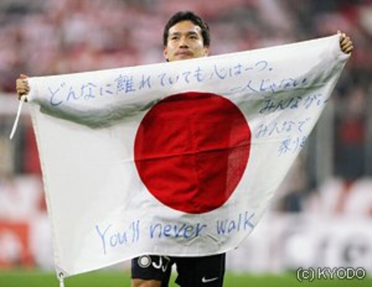 バイエルン戦後、アリアンツ・アレーナに「You'll Never Walk Alone」のFC東京バージョンが流れる間、長友はスタンドに向け日の丸を掲げていた