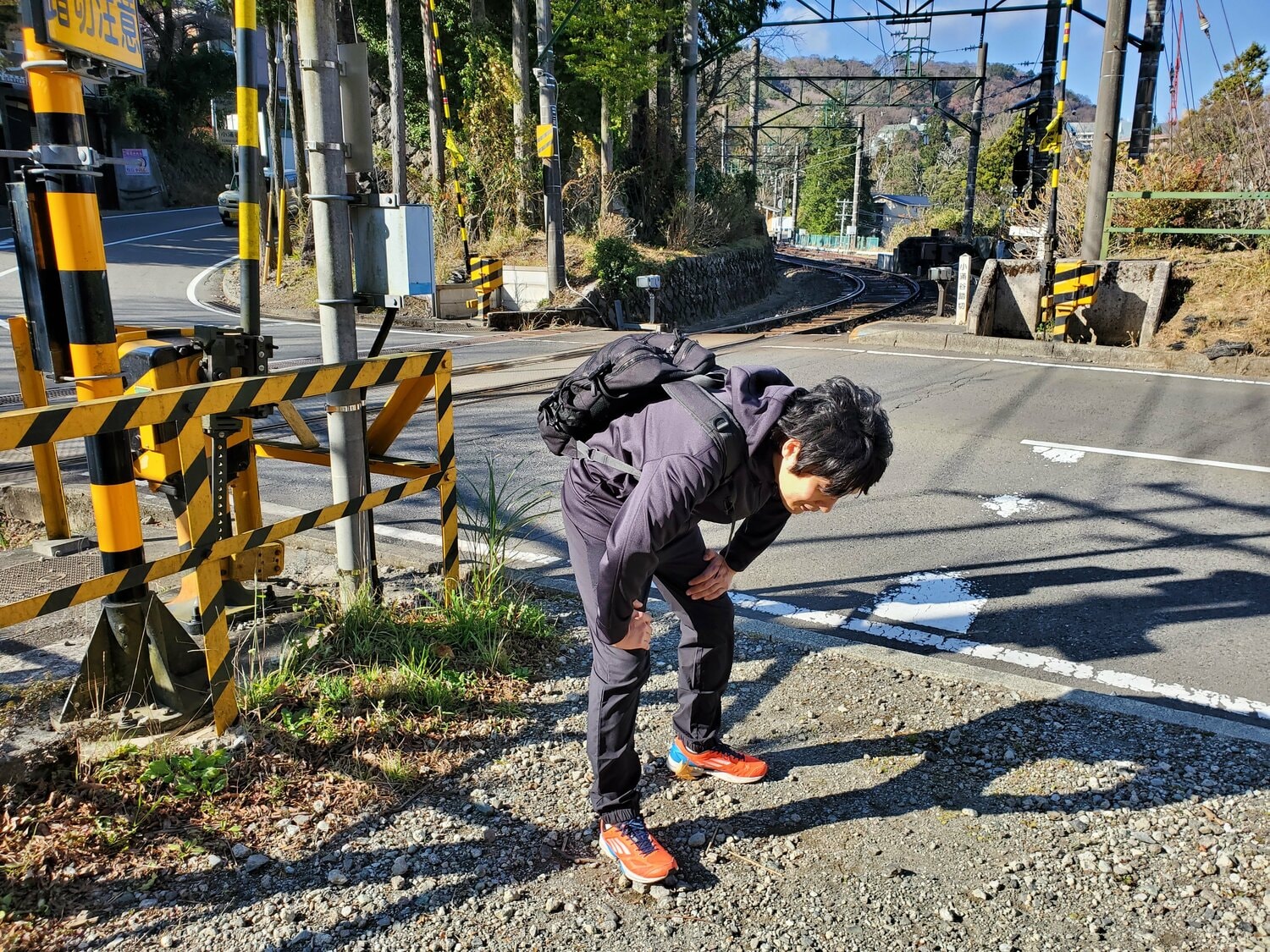 箱根登山鉄道の小涌谷踏切。膝に手をついて休憩する筆者　©Number Web