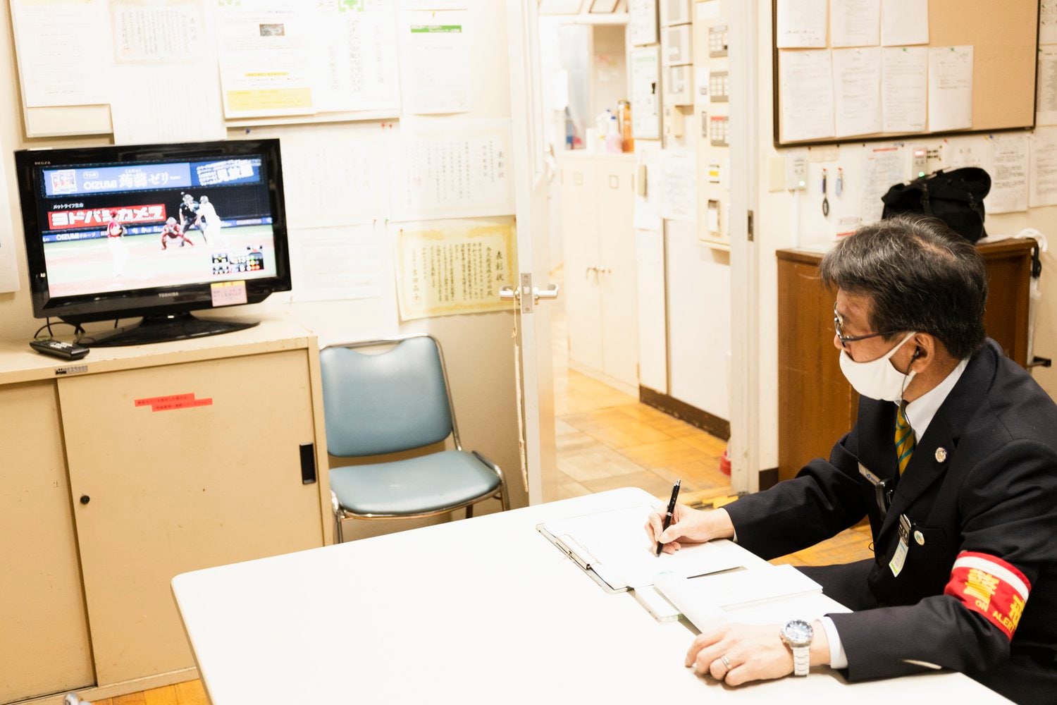 真剣にラスト1イニングの攻防を見つめる、西武球場前駅の松浦駅長