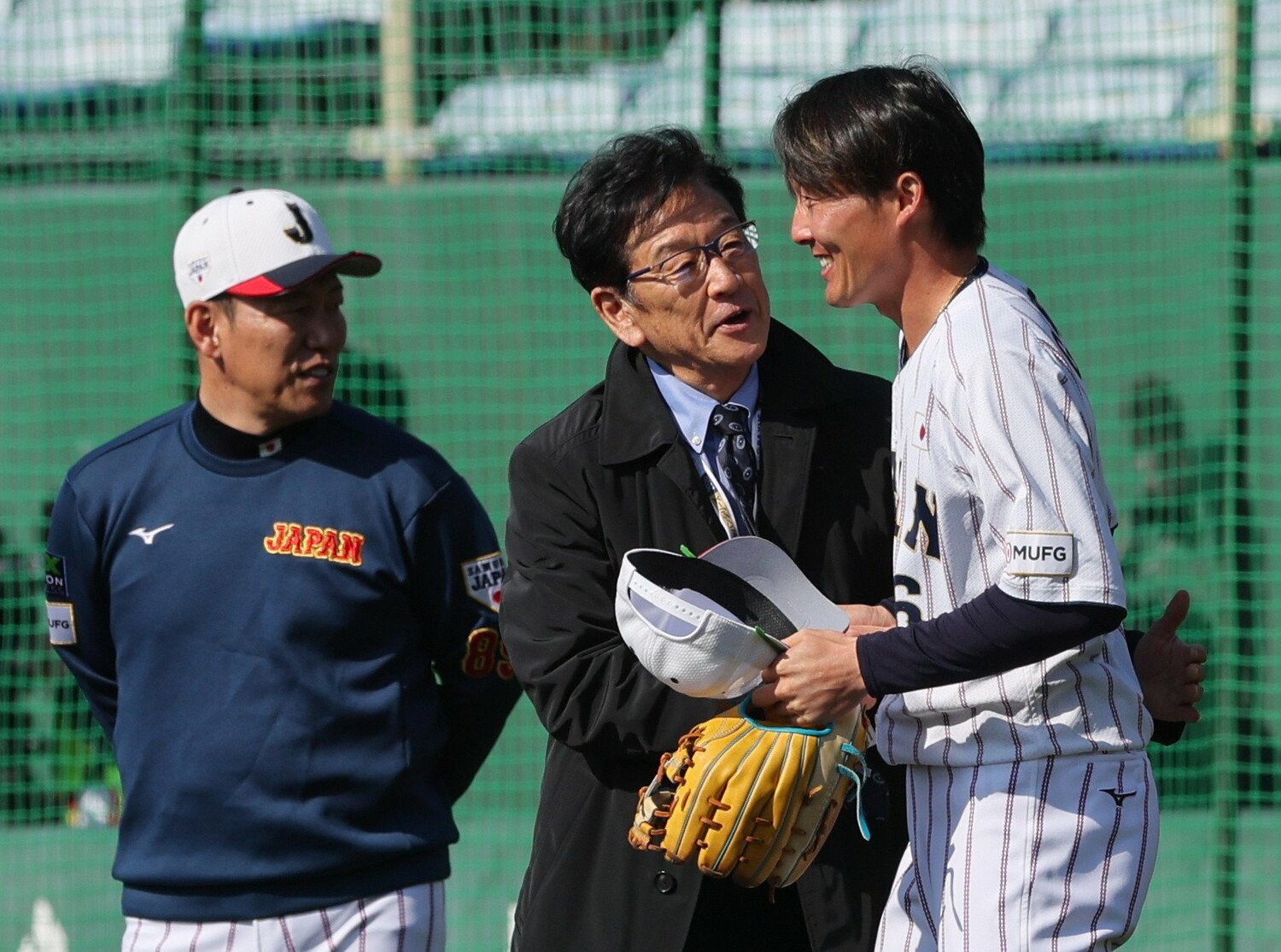 宮崎合宿で、前監督・栗山英樹氏と握手を交わす源田壮亮（右）。左は井端弘和監督　©JIJI PRESS