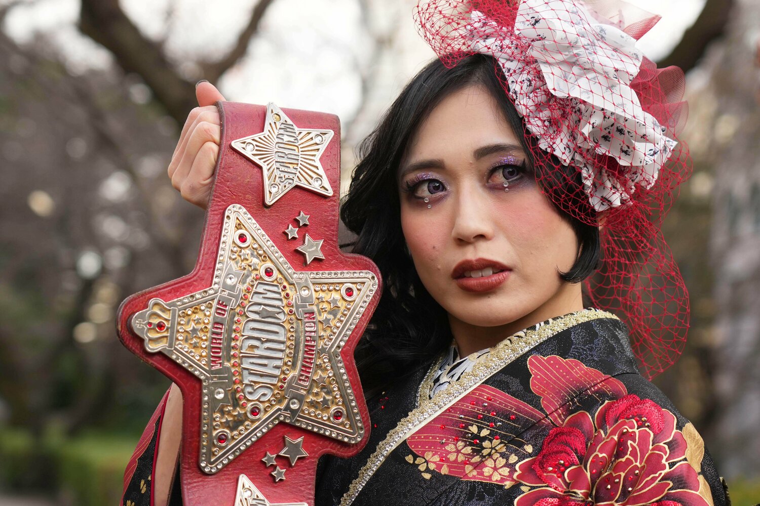 振袖姿で赤いベルトを掲げる上谷沙弥 ©Essei Hara