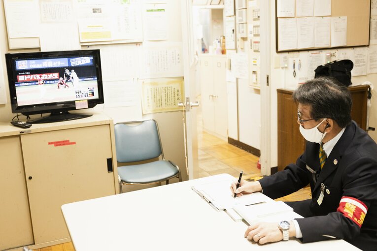 真剣にラスト1イニングの攻防を見つめる、西武球場前駅の松浦駅長