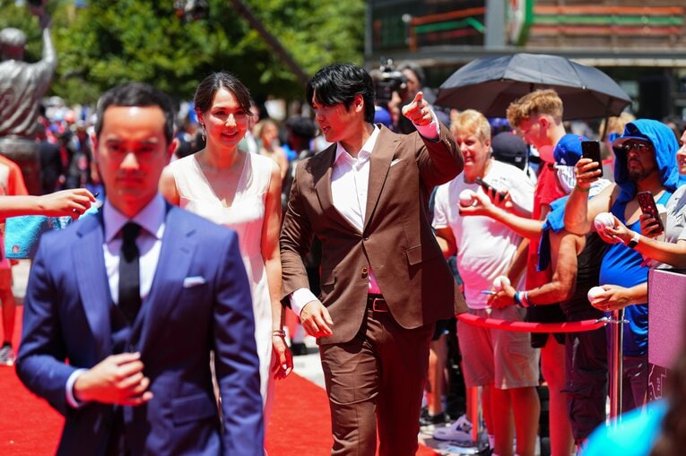 試合前のレッドカーペットに登場した大谷翔平と真美子夫人。左前方にアイアトン通訳　©Getty Images