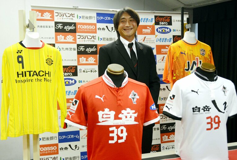 歴代のユニフォームを前に、笑顔で引退会見を終えた北嶋　©︎KYODO