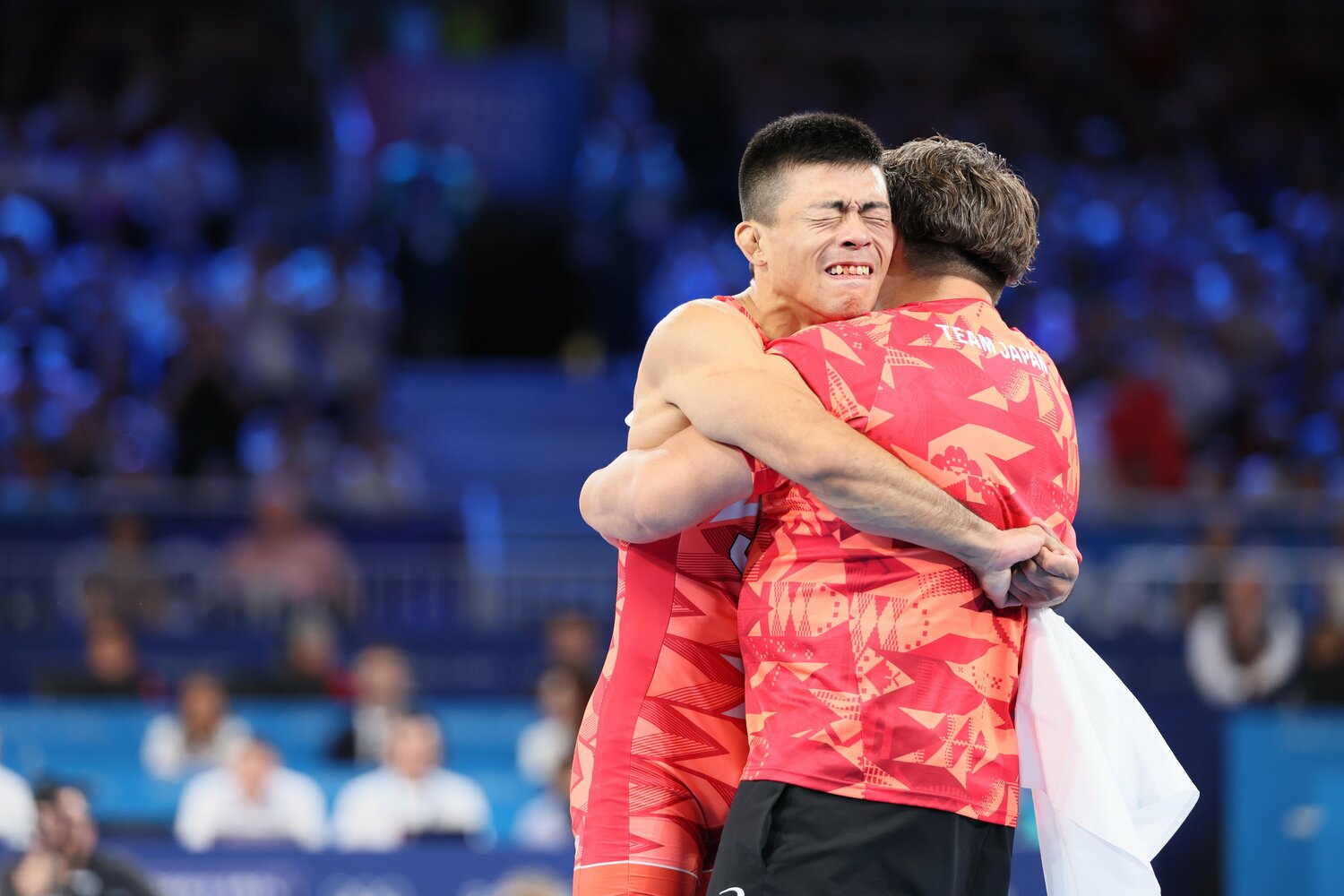 日本のグレコローマンとしては40年ぶりの金メダルを決め、笹本睦コーチと抱き合う文田健一郎 ©JMPA