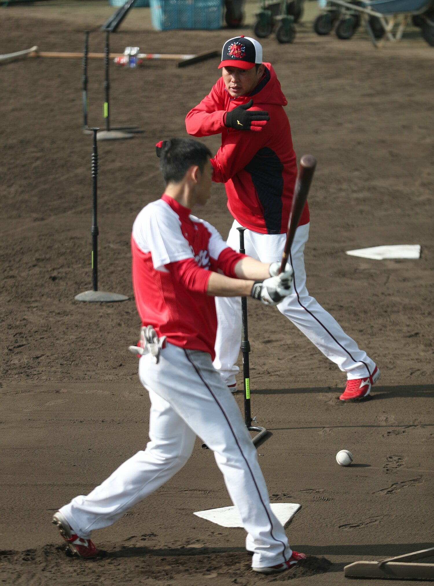 全体練習終了後、新井監督は身振り手振りで秋山に打撃指導を行った　©JIJI PRESS