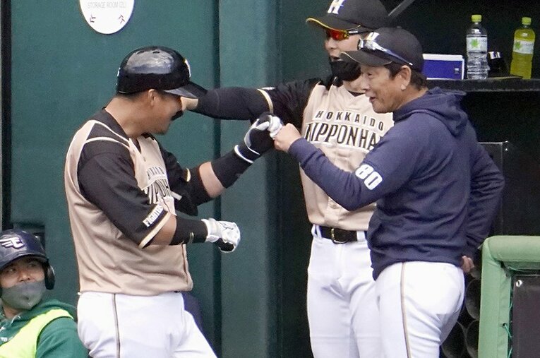 練習試合で本塁打を放った中田をグータッチで迎える栗山監督。日本ハムは1日、沖縄・名護で行った春季キャンプを打ち上げた ／ photograph by Kyodo News