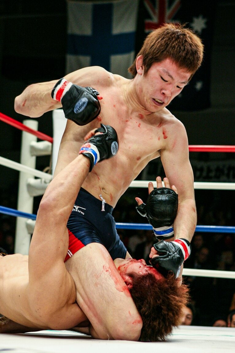 2005年11月6日の弘中邦佳戦。出血する相手にパウンドを落とす青木真也　©Susumu Nagao