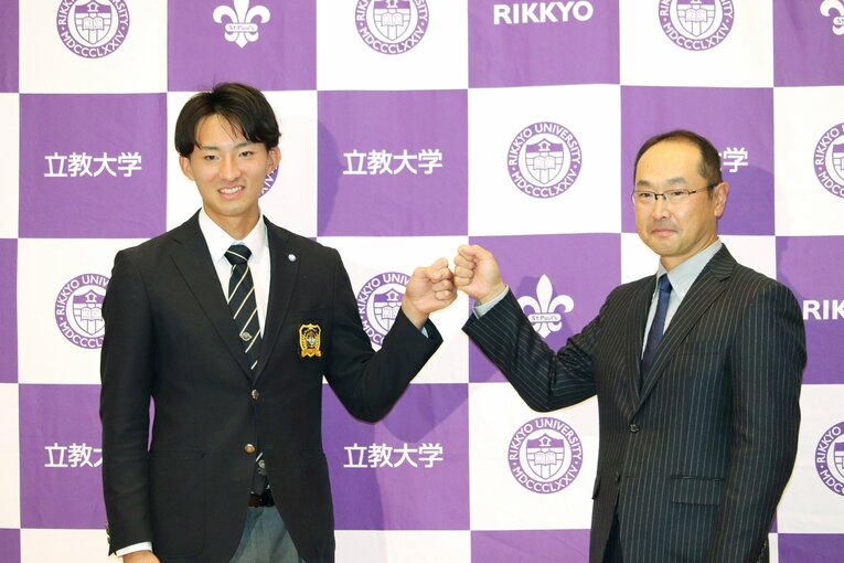 楽天に1位指名され、笑顔でポーズを取る立大の荘司康誠投手と溝口智成監督　©︎JIJI PRESS