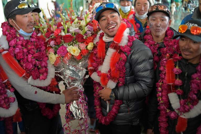 K2の冬季登頂成功後、イスラマバードの空港でメディアの取材に応じるニルマル・プルジャら（1月21日撮影）　©AFLO