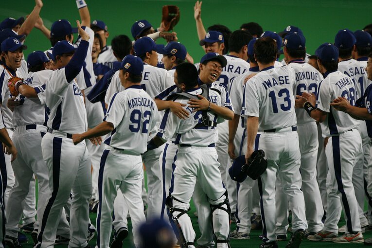 “消えた完全試合”の後、捕手・谷繫と喜びを分かち合う山井　©BUNGEISHUNJU