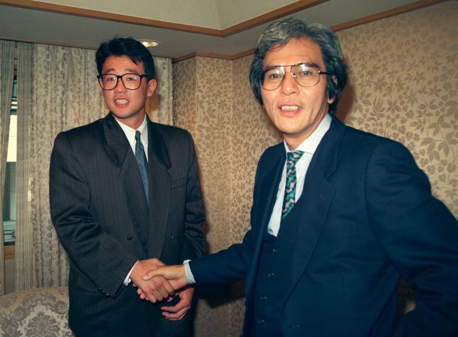 写真は1989年12月。ヤクルトと仮契約を済ませ片岡宏雄スカウト部長（当時）と握手するドラフト2位の古田敦也（トヨタ自動車）　©Sankei Shimbun