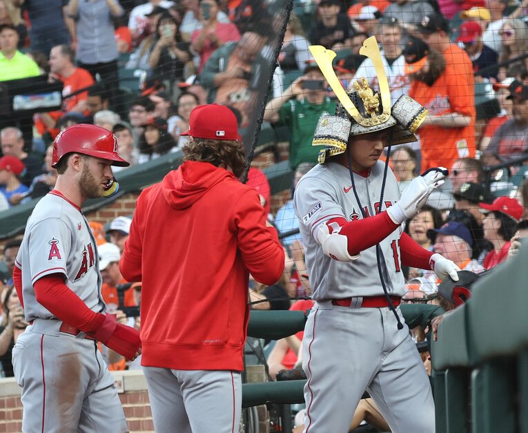 兜をかぶったままベンチ内をスタスタ行進？　©JIJI PRESS