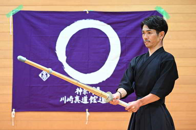 道場旗の前で　©Keiji Ishikawa