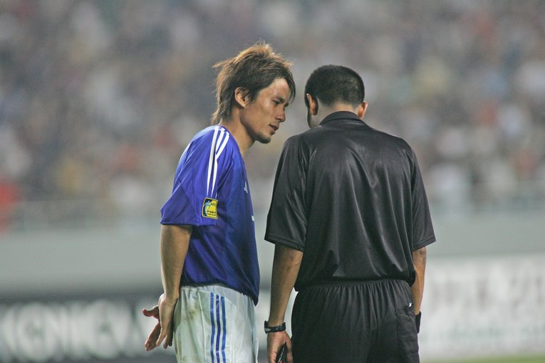 俊輔、三都主の2人が立て続けに足をとられた後、レフェリーにエンド変更の交渉をする主将・宮本恒靖　©AFLO