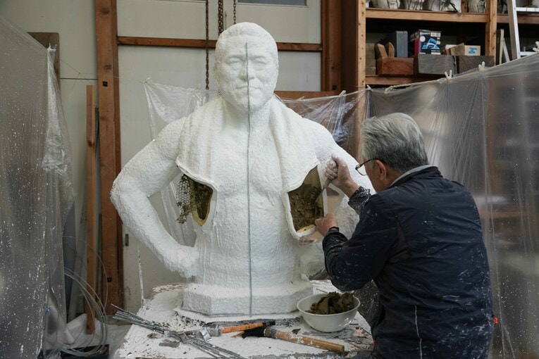 5月12日、切り離したマフラーの部分から粘土をかきだす井野雅文さん