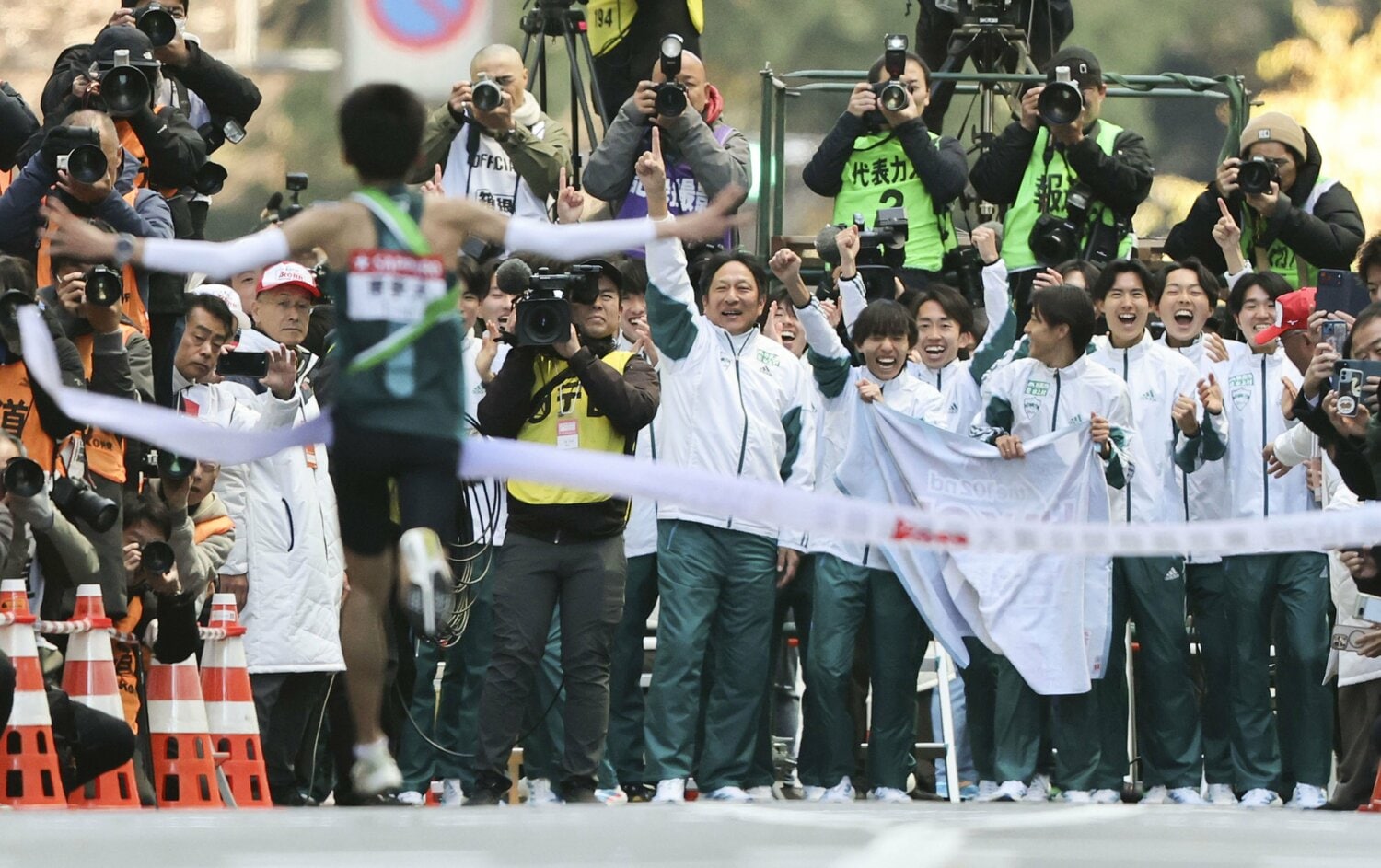 アンカー折田壮太（手前）を迎える青学大・原晋監督とチームメート。3年連続9度目の総合優勝を果たした　©KYODO