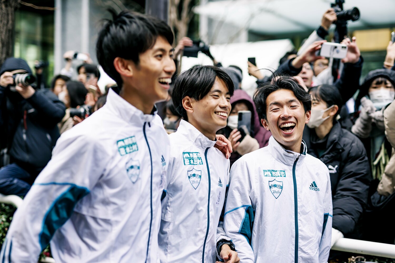 ゴール直後、優勝を喜び合う田中悠登（左）、若林宏樹（中）と、田中との「乾杯給水」を見せた片山宗哉（右）　©Kiichi Matsumoto