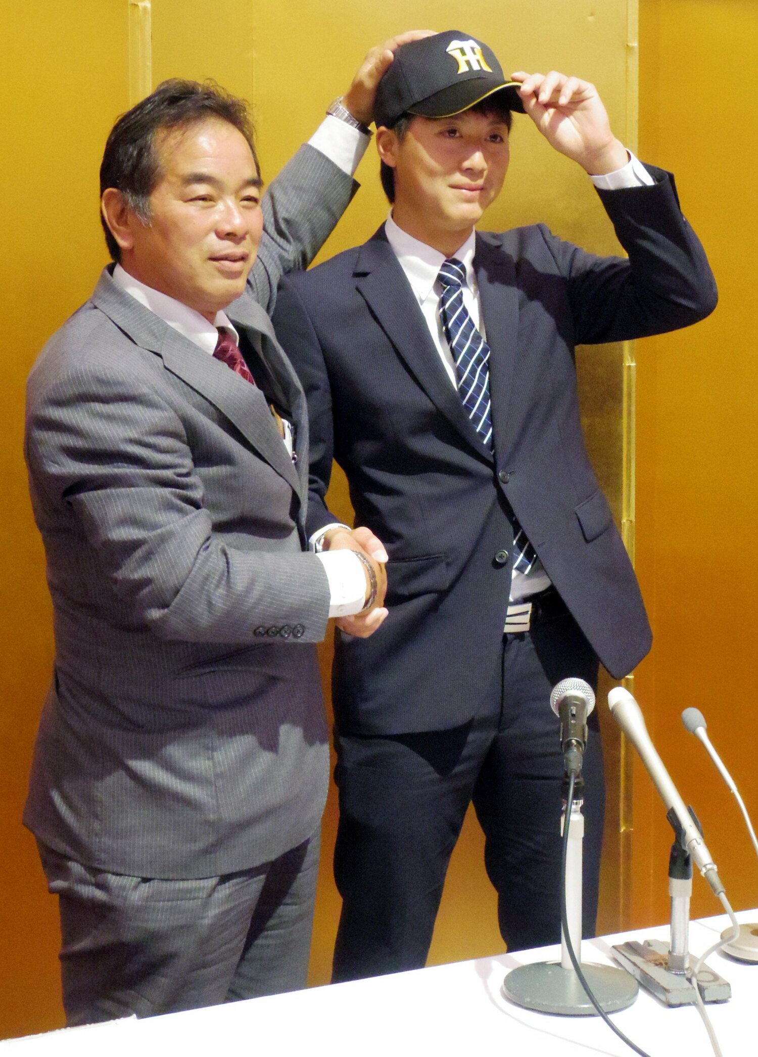 中尾スカウト（当時）から帽子を受け取った横山雄哉（2014年）©︎JIJI PRESS