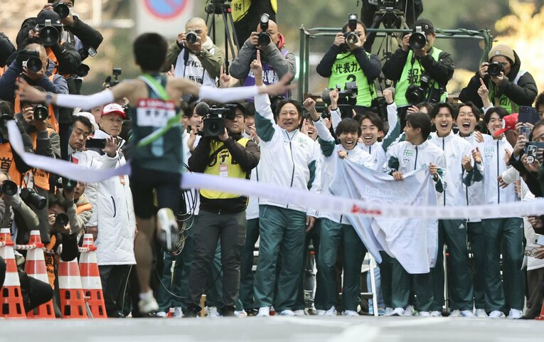 【今年の箱根駅伝】アンカー折田壮太（手前）を迎える青学大・原晋監督とチームメート。3年連続9度目の総合優勝を果たした　©KYODO