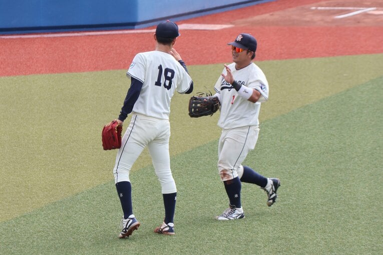 公式戦でチームメイトとハイタッチを交わす花園大の藤原聡大　©Fumi Sawai