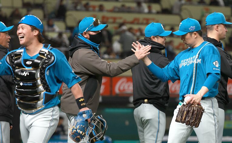 今季開幕2戦目でセーブを記録した田中正義を出迎える新庄剛志監督　©︎SANKEI SHIMBUN