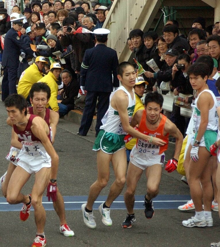 苦しげな表情で2区の加藤健一朗に襷をつなぐ白濱三徳　©Sankei Shimbun