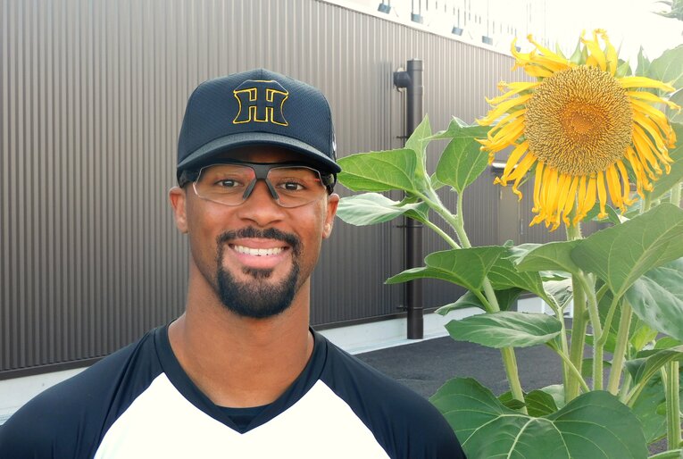 二軍施設の片隅に咲いていた向日葵と笑顔のツーショット　©NumberWeb