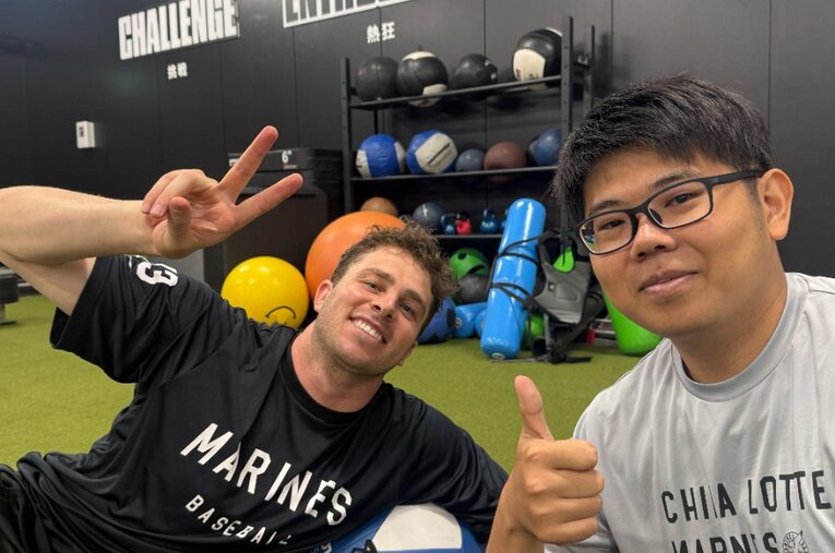 ロングと仲睦まじく会話する村田通訳（右） ／ photograph by Chiba Lotte Marines